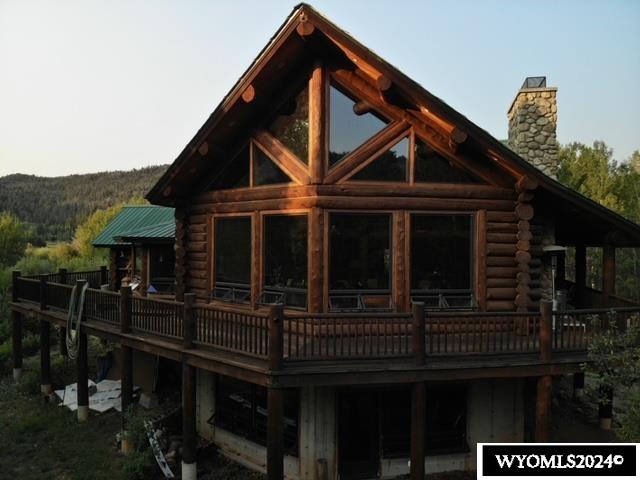 rear view of property featuring a deck with mountain view