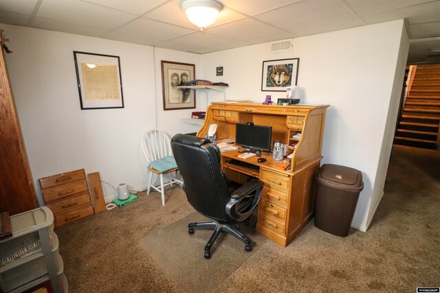 carpeted office with a paneled ceiling