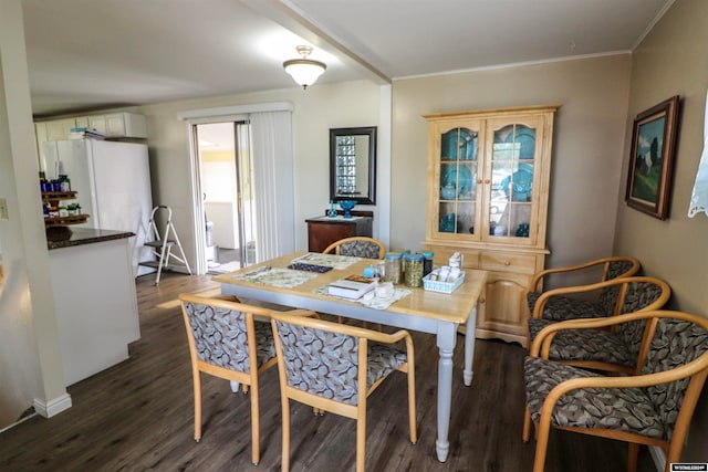 dining area with ornamental molding and dark hardwood / wood-style flooring