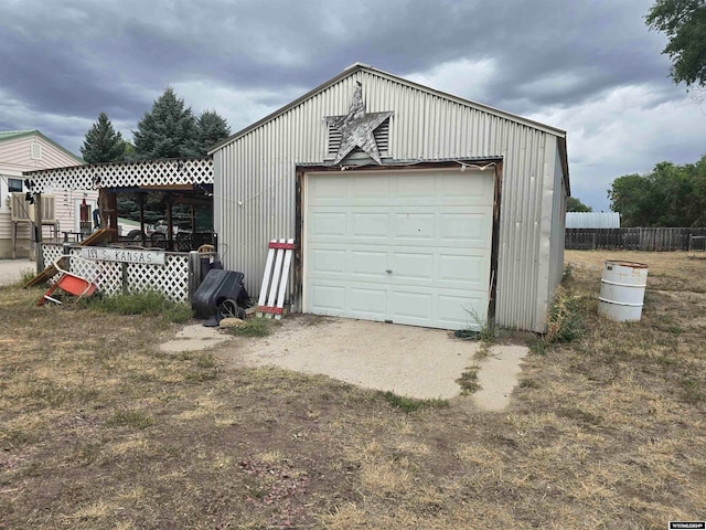 detached garage with fence and driveway