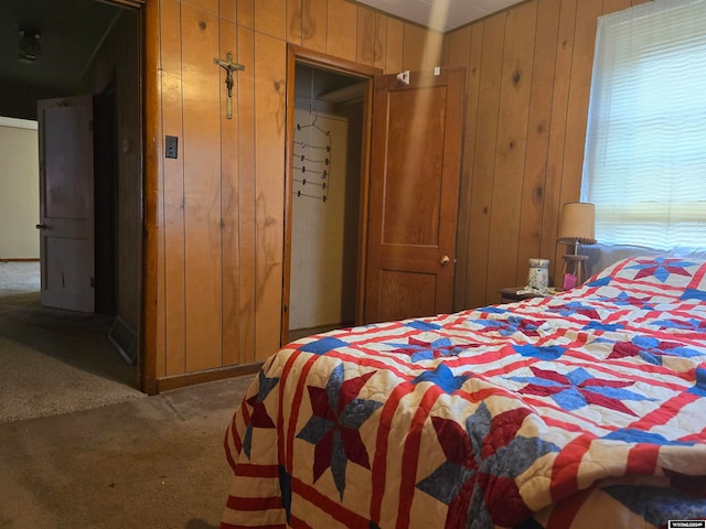 bedroom featuring wooden walls and carpet flooring