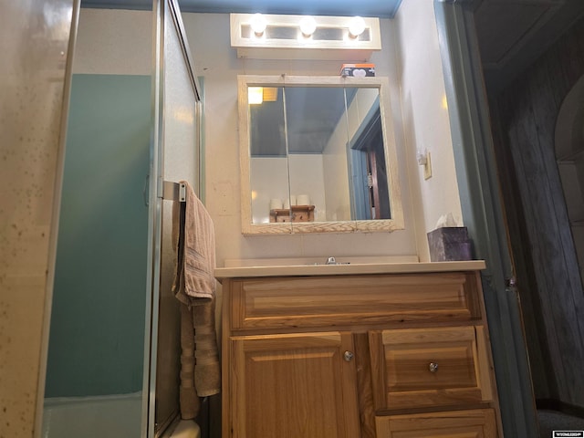 full bathroom with a shower with door and vanity