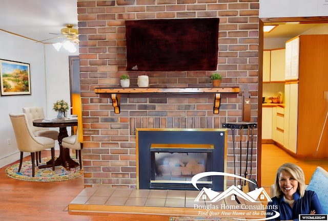 interior details with hardwood / wood-style flooring, ceiling fan, and a brick fireplace