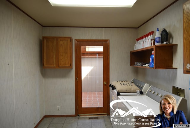 laundry room with cabinets, light tile patterned flooring, and washing machine and dryer