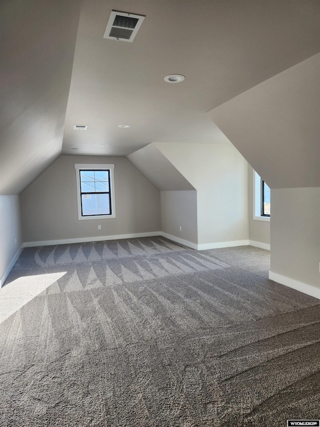 bonus room featuring carpet floors, lofted ceiling, and plenty of natural light