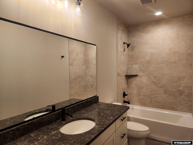 full bathroom featuring tiled shower / bath combo, vanity, and toilet