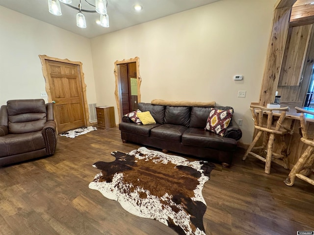 living room featuring a notable chandelier and dark wood-type flooring