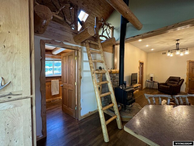 interior space featuring vaulted ceiling with skylight, a wood stove, and hardwood / wood-style flooring