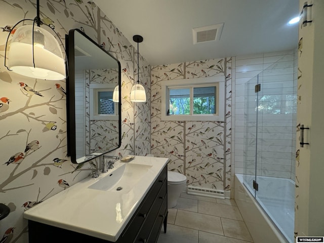 full bathroom with tile patterned floors, bath / shower combo with glass door, vanity, and toilet