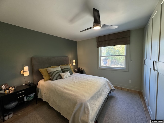 bedroom with dark hardwood / wood-style flooring and ceiling fan