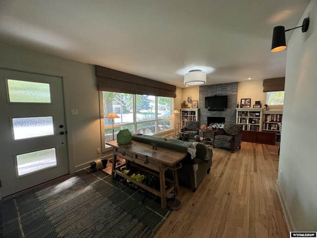 living room with hardwood / wood-style flooring, a fireplace, and a healthy amount of sunlight