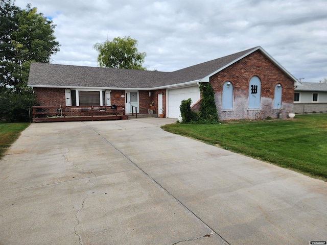 ranch-style house featuring a garage and a front lawn