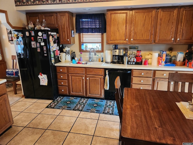 kitchen with black appliances, sink, and light tile patterned floors