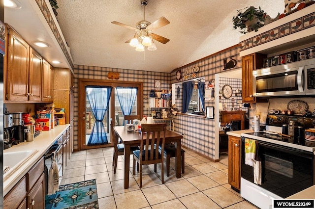 2226 E I St, Torrington, WY 82240 - kitchen featuring electric range, stainless steel microwave, a textured ceiling, ceiling fan, and wallpapered walls