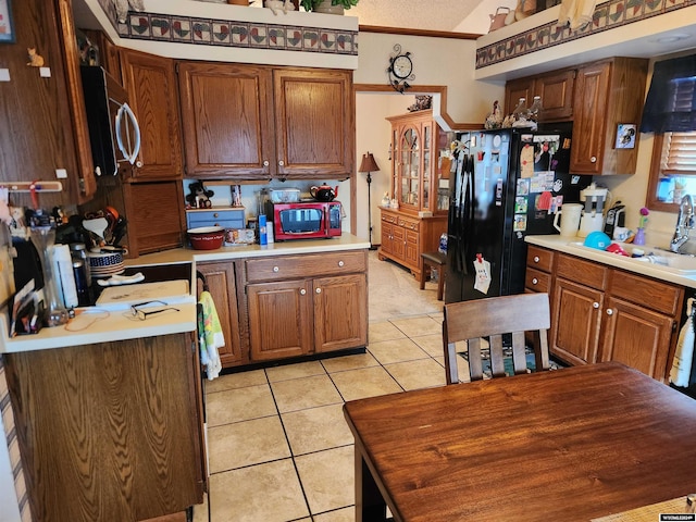 kitchen with light tile patterned flooring, a textured ceiling, and sink