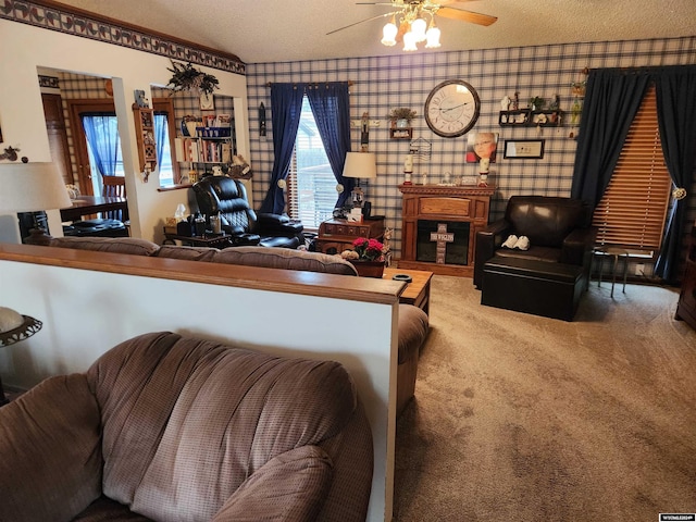 living room with ceiling fan, a textured ceiling, and carpet