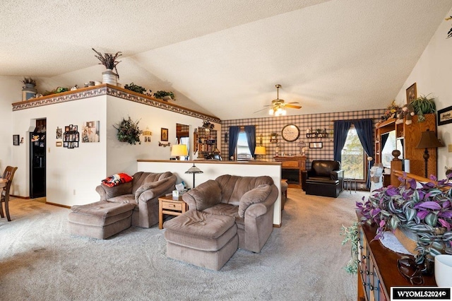 carpeted living room with ceiling fan, a textured ceiling, brick wall, and lofted ceiling