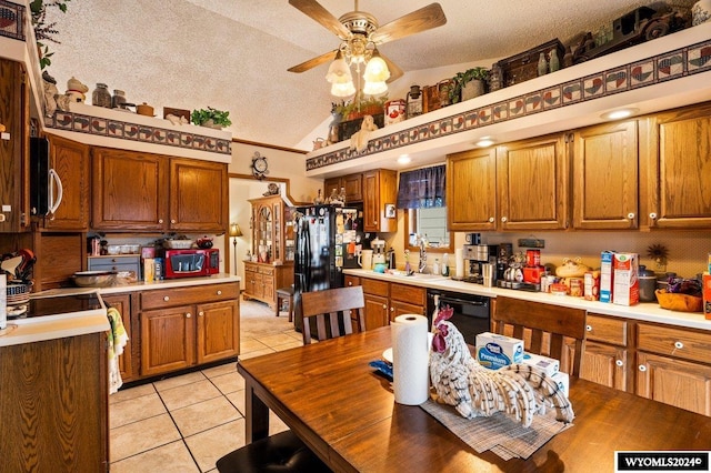 kitchen featuring a textured ceiling, light tile patterned floors, black appliances, and lofted ceiling