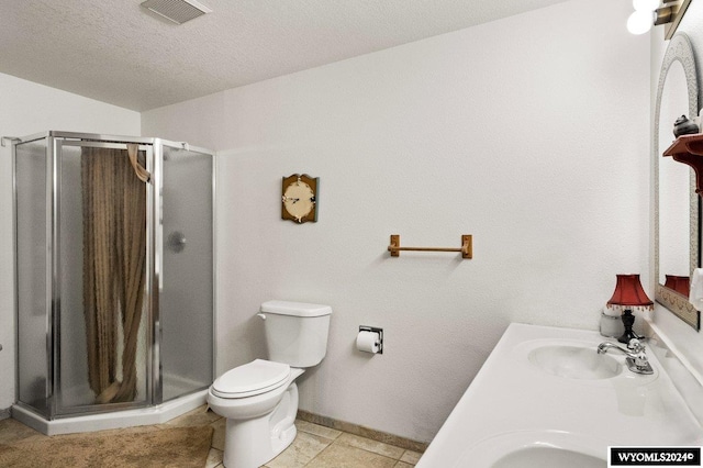 bathroom featuring an enclosed shower, vanity, a textured ceiling, and toilet