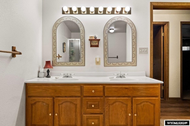 bathroom featuring an enclosed shower, wood-type flooring, and vanity