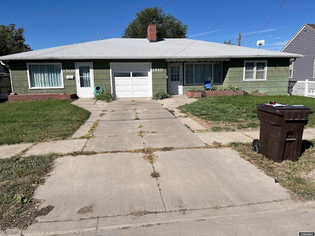 ranch-style home with a garage and a front lawn