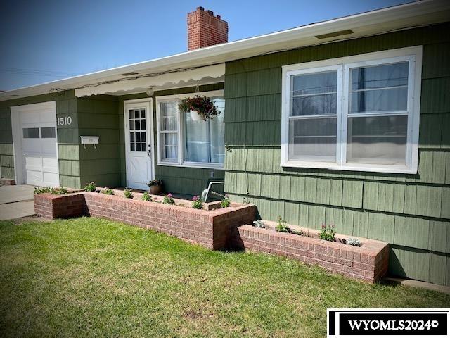 property entrance featuring a garage and a yard