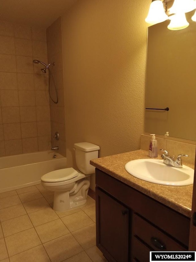 full bathroom featuring vanity, tile patterned flooring, tiled shower / bath, and toilet