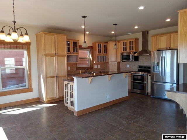 kitchen featuring decorative backsplash, wall chimney exhaust hood, stainless steel appliances, decorative light fixtures, and a notable chandelier