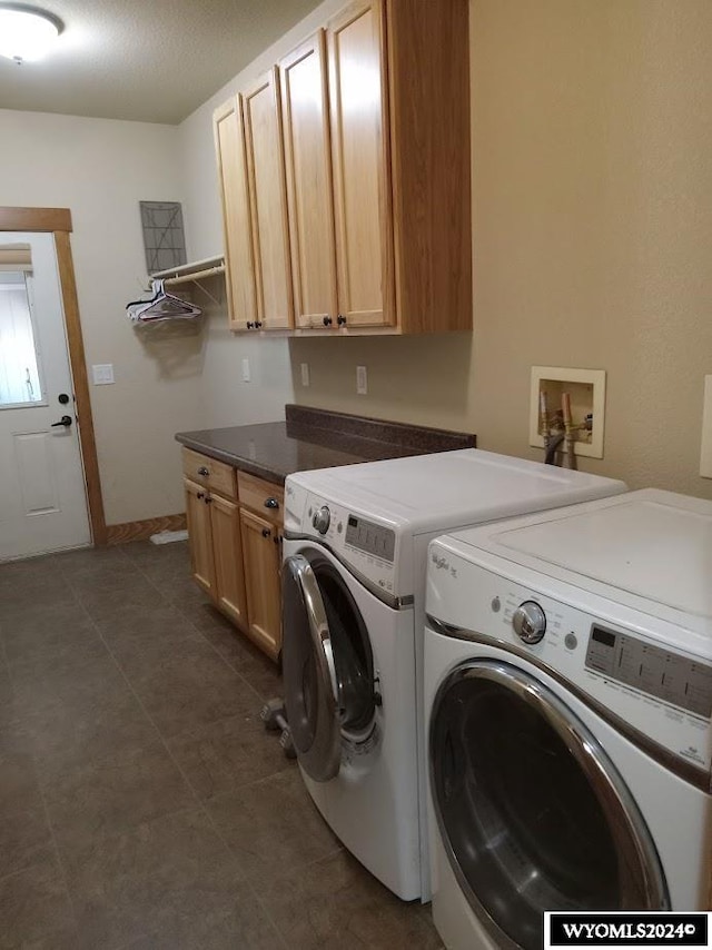 laundry room featuring washer and dryer and cabinets