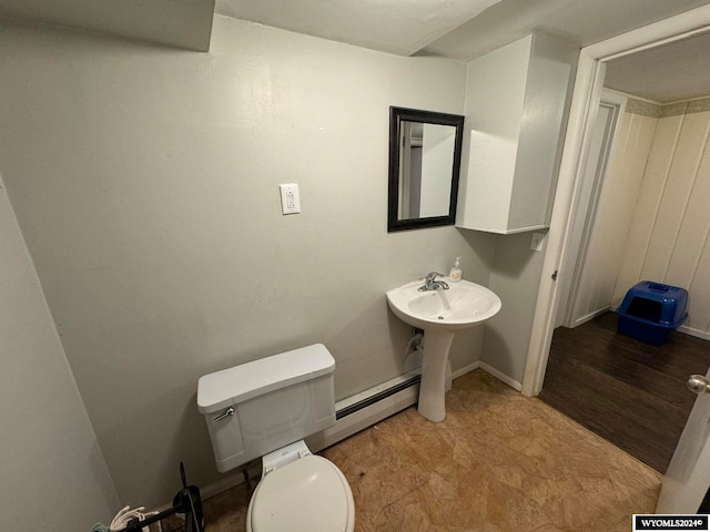 bathroom with hardwood / wood-style floors, toilet, and a baseboard heating unit