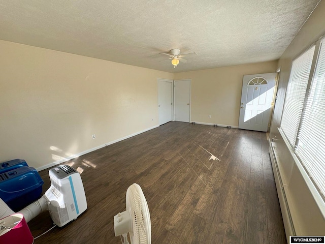 empty room with ceiling fan, dark hardwood / wood-style floors, and a textured ceiling