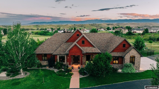 view of front of house with a mountain view and a lawn