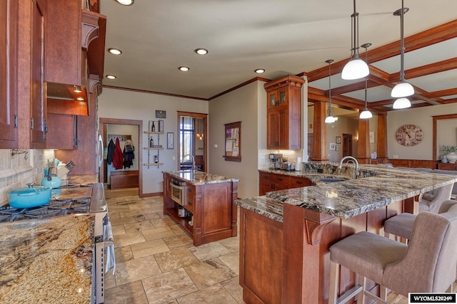 kitchen with dark stone counters, kitchen peninsula, a kitchen island, decorative backsplash, and decorative light fixtures