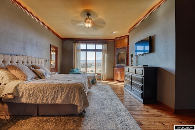 bedroom featuring light hardwood / wood-style flooring, ceiling fan, and ornamental molding