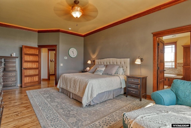 bedroom featuring ceiling fan, ensuite bath, light hardwood / wood-style flooring, and crown molding