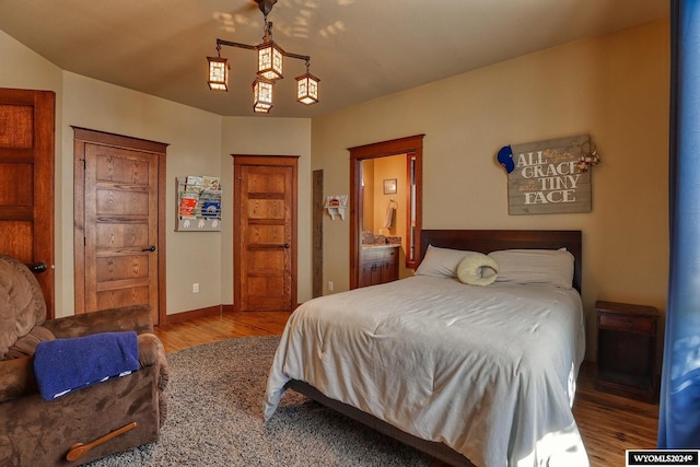 bedroom with wood-type flooring and connected bathroom