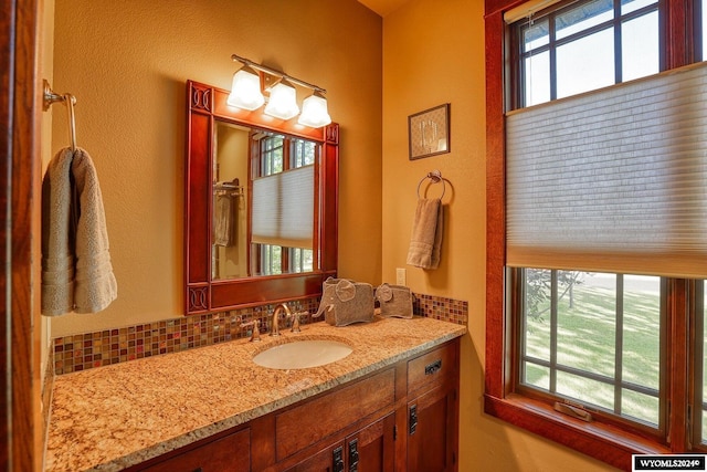 bathroom featuring vanity, a healthy amount of sunlight, and tasteful backsplash