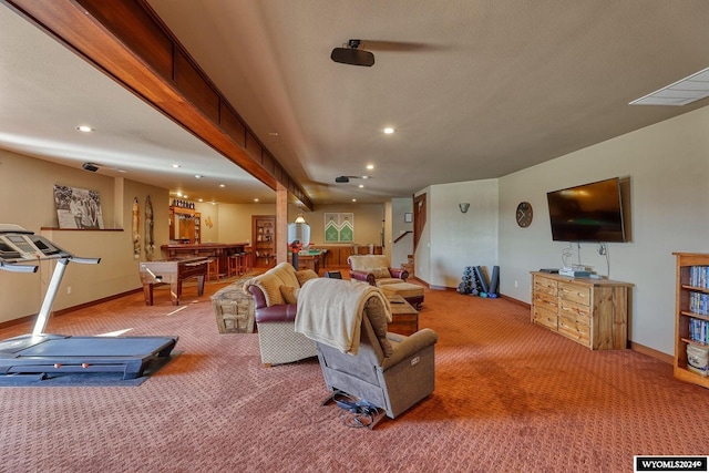 carpeted living room with bar and beamed ceiling