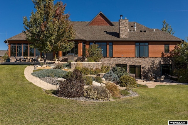 rear view of house with a yard and a patio area