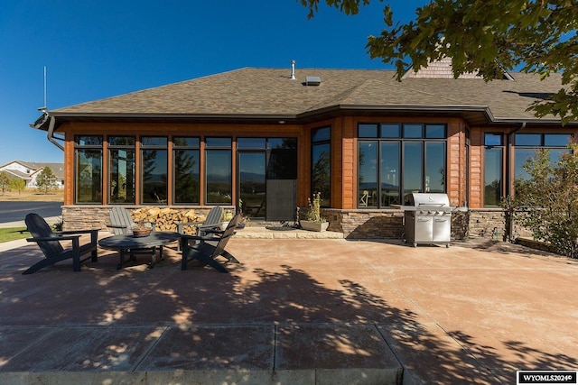 rear view of house with a patio, exterior kitchen, and a fire pit