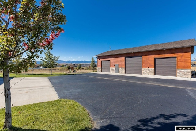 garage featuring a mountain view and a yard