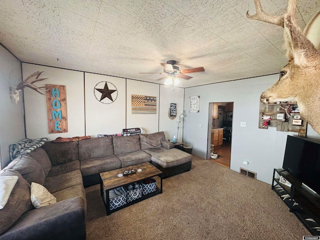 carpeted living room with ceiling fan