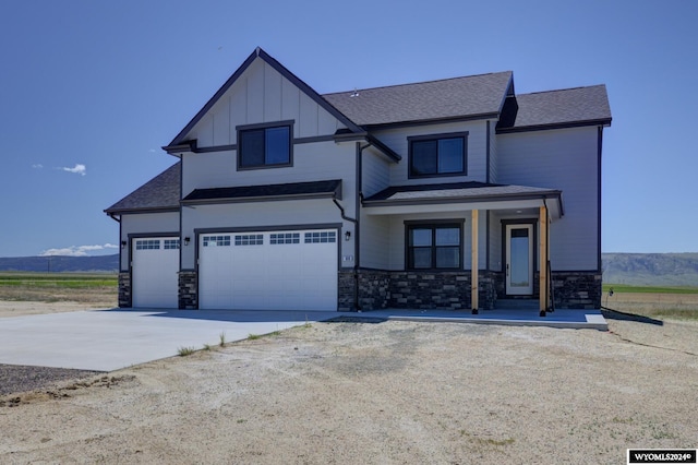 view of front of home with a mountain view, covered porch, and a garage