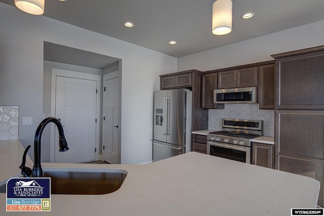 kitchen featuring dark brown cabinets, appliances with stainless steel finishes, sink, and decorative backsplash