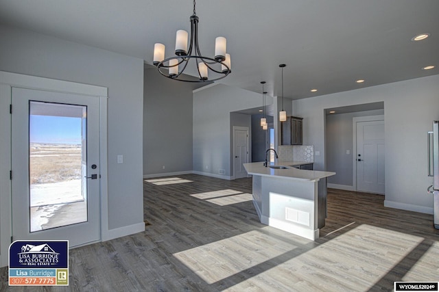 kitchen featuring pendant lighting, dark wood-type flooring, sink, a notable chandelier, and refrigerator