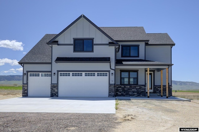 view of front facade with a porch, a garage, and a mountain view