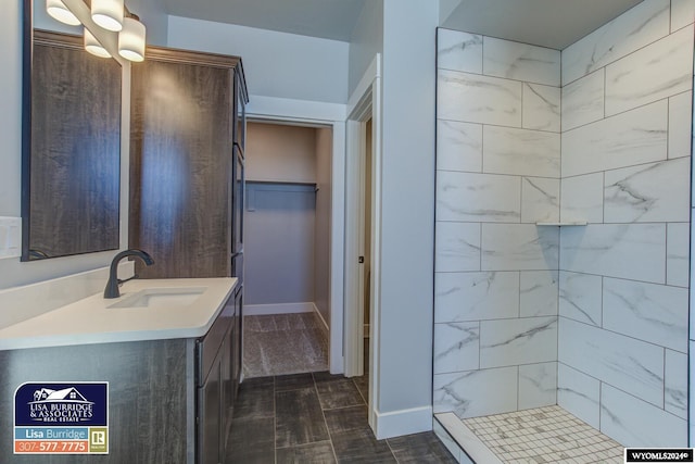 bathroom featuring tiled shower and vanity