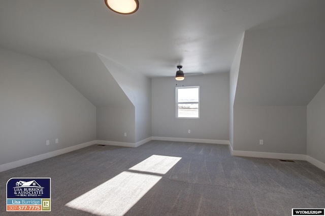 additional living space with ceiling fan, lofted ceiling, and dark colored carpet