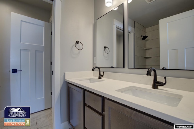 bathroom with tile patterned flooring, vanity, and tiled shower