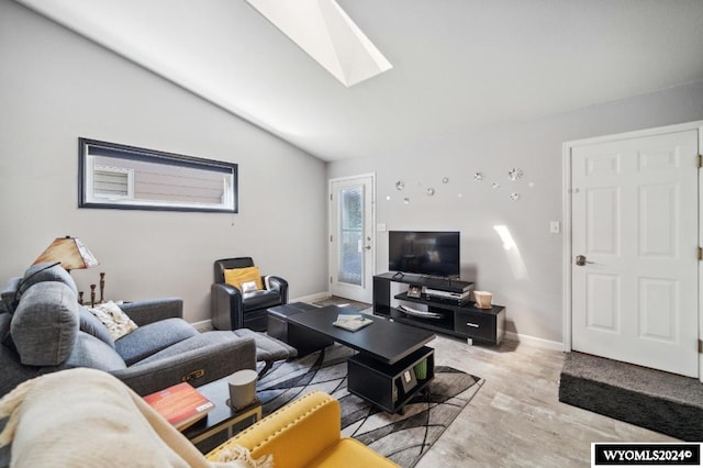 living room featuring vaulted ceiling with skylight and light hardwood / wood-style floors